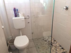 斯特兰德Romilly Beach Apartment的一间带卫生间和玻璃淋浴间的浴室