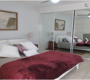 斯特兰德Romilly Beach Apartment的一间卧室配有一张大床和镜子