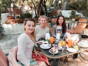 阿吉亚玛丽娜海豚酒店的一群三个女人坐在餐桌旁吃着食物
