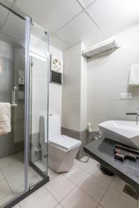 甘地讷格尔绝佳团体酒店的浴室配有卫生间、盥洗盆和淋浴。