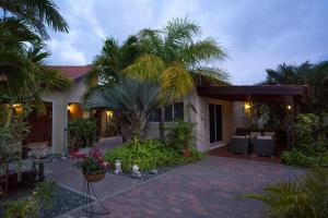 棕榈滩斯梅拉达村海滨度假屋的棕榈树和庭院的房子
