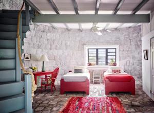 尼维斯Golden Rock Nevis的一间设有两张床和一张桌子及椅子的房间