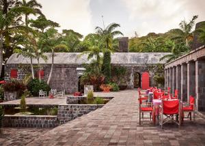 尼维斯Golden Rock Nevis的庭院设有红色的桌椅和喷泉