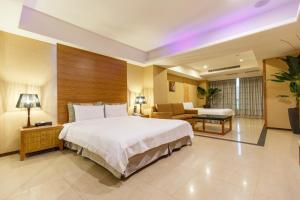 中和SLV旅馆集团 - 君迪馆的酒店客房设有一张大床和一张沙发。