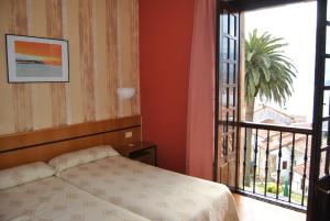 拉斯特雷斯帕拉西奥德洛斯巴利亚多斯酒店的一间卧室设有一张床和一个大窗户