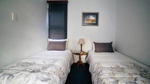 赫罗德斯湾Coo-ee 9的两张睡床彼此相邻,位于一个房间里