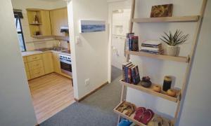 赫罗德斯湾Coo-ee 9的一间设有黄色橱柜的小厨房和一间带书架的房间