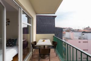 波尔图OPO Bolhao Flats by Destiny Houses的阳台配有桌椅和1张床。