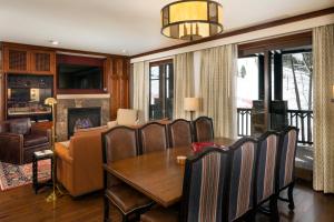 阿斯潘Ritz Carlton, Aspen Highlands的一间带桌椅和壁炉的用餐室