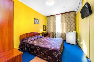 秋明Hotel Filton的卧室配有一张床铺,位于一个黄色墙壁的房间