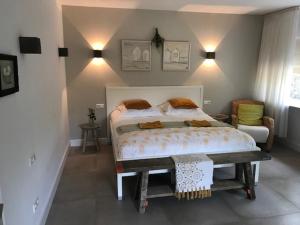 MoergestelHet Ockhuis的一间卧室配有一张大床和一把椅子