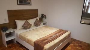 马尼拉马卡蒂吉瓦希酒店的一间卧室,卧室内配有一张大床