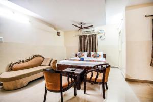 蒂鲁帕蒂FabHotel Aditya Yatri Nivas的配有床、桌子和沙发的房间