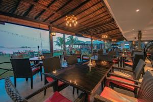 特鲁克巴库民丹岛别墅海滩温泉度假酒店的一间带桌椅的海景餐厅