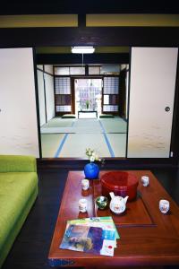 近江八幡市Guesthouse Mio的一间带桌子的客厅和一间带庭院的房间