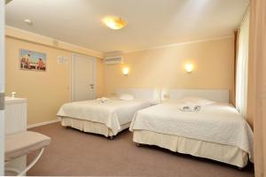 基辅莱特及哈勃酒店的一间设有两张带白色床单的床的房间