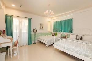 吉安法式棉花糖民宿的一间卧室设有两张床和绿色窗帘