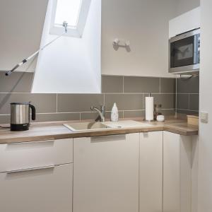 OttersbergHaus Biederstaedt的厨房配有白色橱柜和水槽