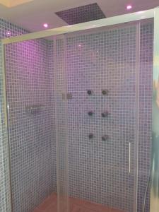 伊斯基亚Aparthotel Villa Marinù的带淋浴的浴室(铺有粉红色瓷砖)