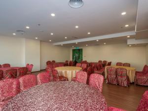 努沙再也Hotel Holmes Gp的一间会议室,配有红色的桌椅和屏幕