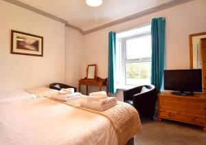 埃斯克代尔布鲁克之家宾馆的一间卧室设有两张床、一台电视和一扇窗户。