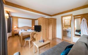 奥蒂塞伊Rainell Dolomites Retreat的带沙发的客厅和卧室