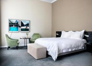 兹沃勒Pillows Grand Boutique Hotel Ter Borch Zwolle的卧室配有一张白色大床和一把椅子