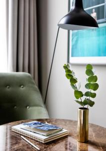 兹沃勒Pillows Grand Boutique Hotel Ter Borch Zwolle的一张桌子,上面有台灯和花瓶,上面有植物