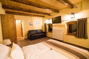 兹雷切Gorska Reka Guesthouse的一间卧室配有一张床和一张皮沙发