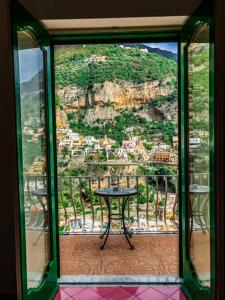 波西塔诺维拉韦尔德酒店的山前带桌子的玻璃窗
