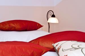 诺怎温德膳食公寓的卧室配有红色和白色枕头以及灯