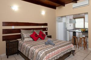 圣卢西亚Manzini Chalets的一间卧室配有一张带红色枕头的床