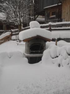 卡普尔Ferienhaus Nadine的板凳旁的雪地堆积的院子
