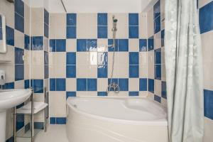 布加勒斯特索非亚别墅的蓝色和白色的浴室设有浴缸和水槽
