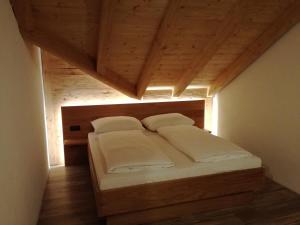 StockenboiWieser Hütte的木天花板的客房内的一张床位