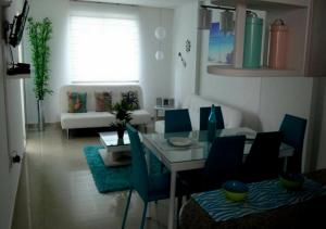 圣玛尔塔Apartamento con Piscina En el Rodadero Santa Marta Colombia的客厅配有桌子和蓝色椅子