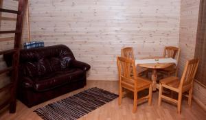 Misso大黄蜂森林之家度假屋的客厅配有真皮沙发和桌椅