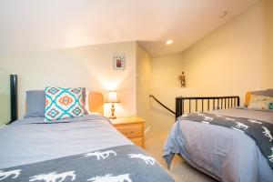 惠斯勒R & R Retreat Luxury Condo的一间卧室设有两张床和一张桌子上的台灯。