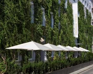 维也纳The Harmonie Vienna, BW Premier Collection的建筑物前的一排白色雨伞