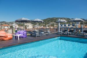 戛纳Best Western Plus Cannes Riviera的屋顶游泳池配有椅子和遮阳伞