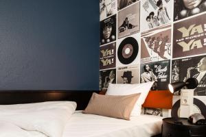 纽伦堡纽伦堡总站贝斯特韦斯特酒店的卧室配有一张带海报的墙壁床。