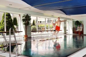 德累斯顿德勒斯顿贝斯特韦斯特马克雷登酒店的跳入游泳池的男人和女人