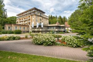 巴特迪尔海姆Sure Hotel by Best Western Bad Dürrheim的前面有白色花的大建筑