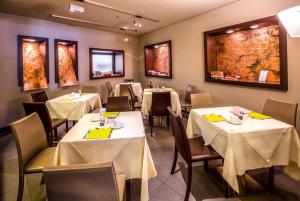 热那亚贝斯特韦斯特大都市酒店的用餐室配有桌椅和黄色餐巾