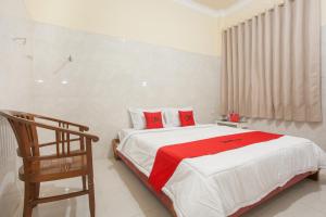 泗水RedDoorz Syariah At Sedati的一间卧室配有一张带红色枕头的大床