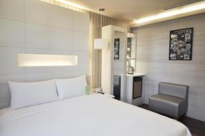 高雄康桥商旅-中山八德馆的卧室配有白色的床和椅子