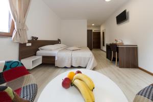 普利特维采湖佛得角别墅十六湖旅馆的酒店客房设有两张床,桌子上放有香蕉