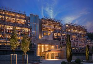 比尔根山Bürgenstock Hotels & Resort - Waldhotel & Spa的黄昏时分拥有许多窗户的大型建筑
