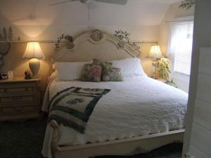 海伦Black Forest Bed & Breakfast的一间卧室配有一张带两盏灯的大型白色床。