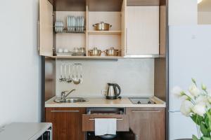 阿德勒伊梅莱汀斯基摩尔思科公寓酒店的一个带木制橱柜和水槽的小厨房